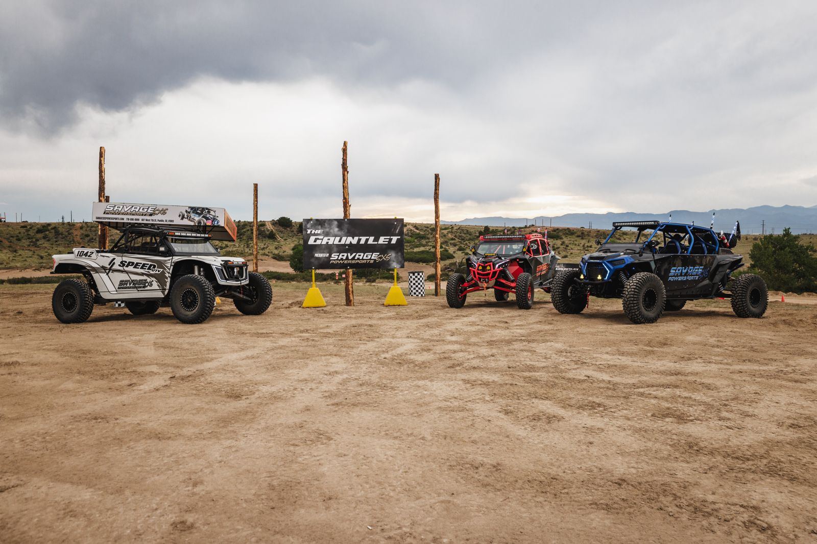 Savage Powersports machines lined up at The Gauntlet sign at Pikes Peak International Raceway