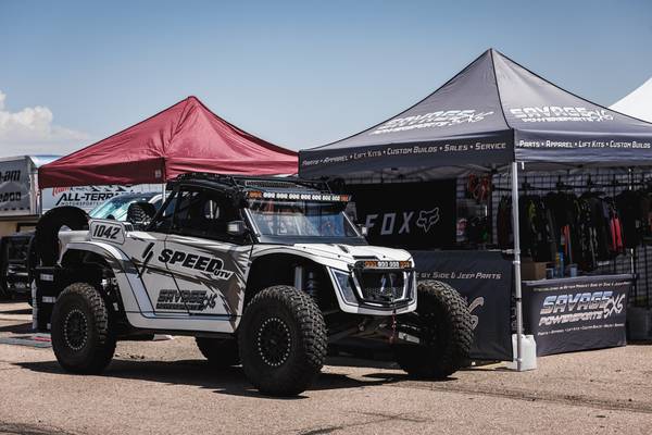 The number 1042 Speed UTV in Savage Powersports graphics outside the Savage tent