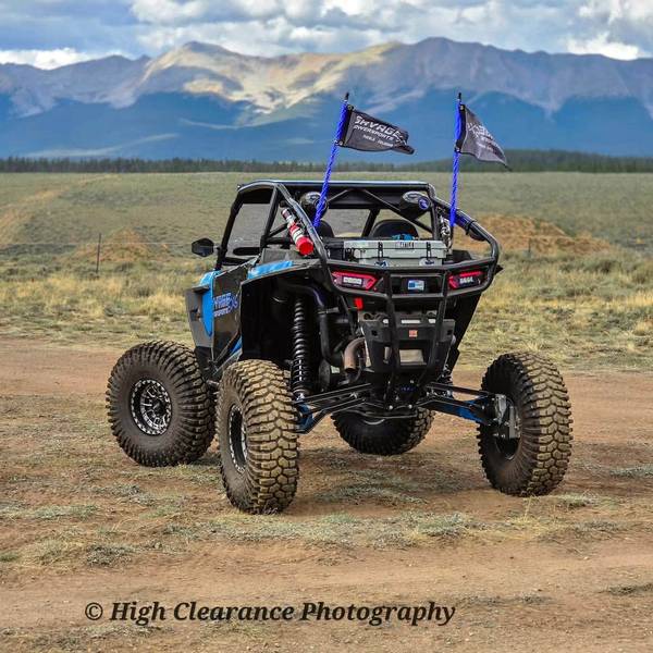 Savage's blue RZR flying Savage flags in front of the mountains