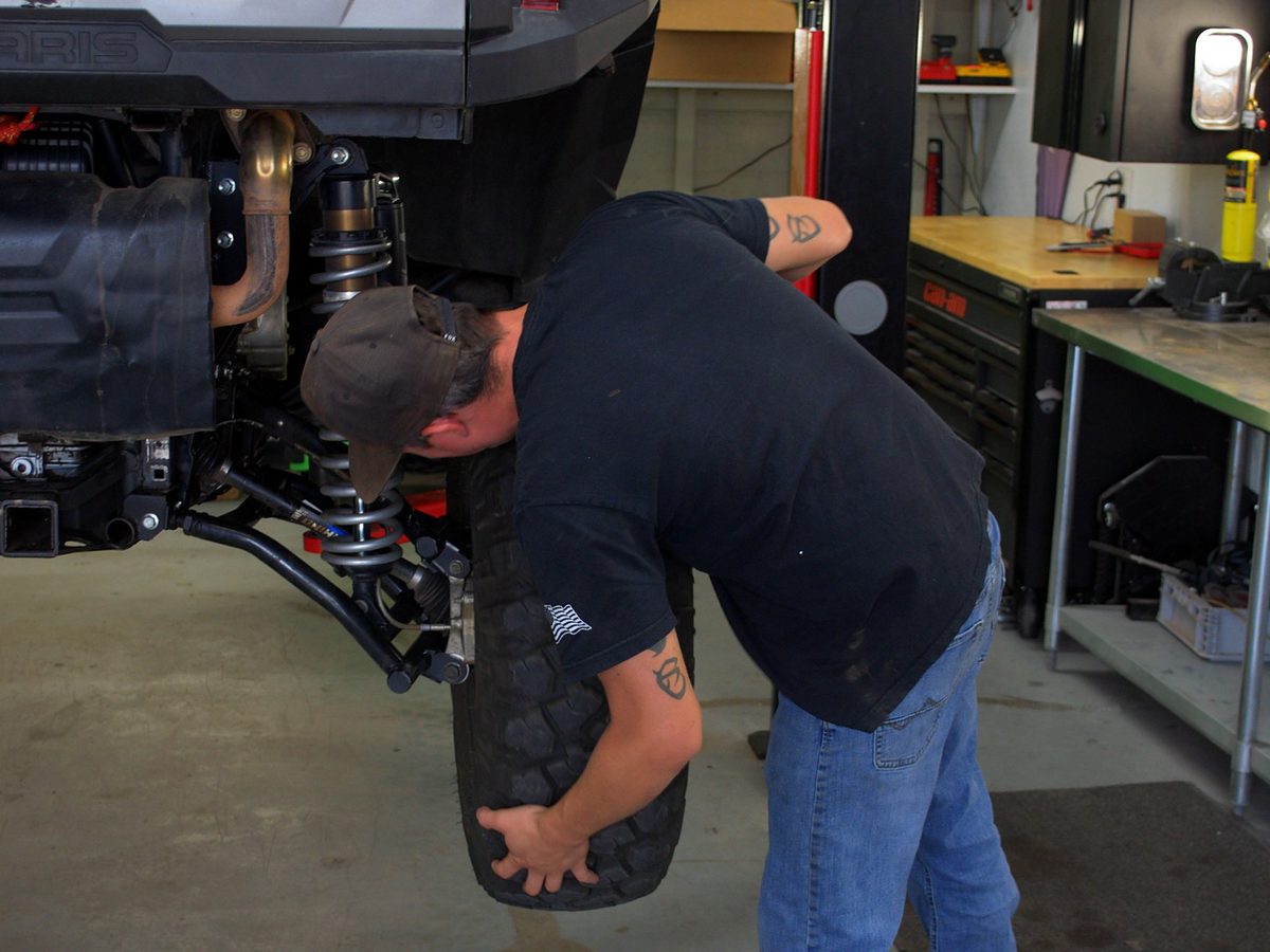 A Savage Powersports technician fitting a wheel